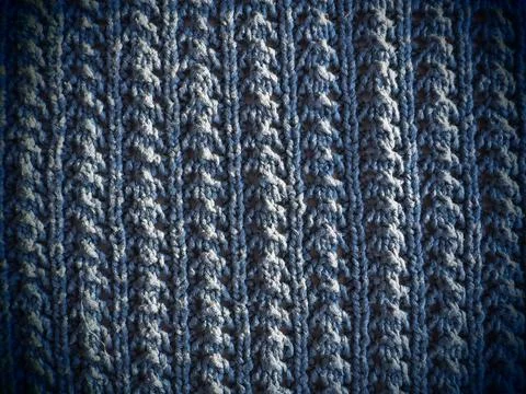 Knitted pattern of blue yarn. Lush machine or hand knitting. Warm wardrobe fo Stock Photos