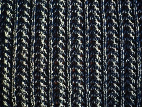 Knitted pattern of blue yarn. Lush machine or hand knitting. Warm wardrobe fo Stock Photos