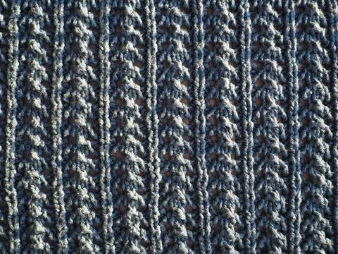 Knitted pattern of blue yarn. Lush machine or hand knitting. Warm wardrobe fo Stock Photos