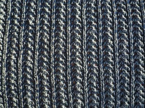 Knitted pattern of blue yarn. Lush machine or hand knitting. Warm wardrobe fo Stock Photos