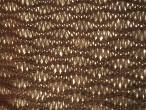 Knitted pattern of brown or beige yarn. Lush machine or hand knitting. Warm w Stock Photos