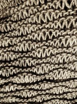 Knitted pattern of brown or beige yarn. Lush machine or hand knitting. Warm w Stock Photos