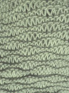 Knitted pattern of gray yarn. Lush machine or hand knitting. Warm wardrobe fo Stock Photos