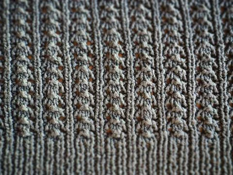 Knitted pattern of gray yarn. Lush machine or hand knitting. Warm wardrobe fo Stock Photos