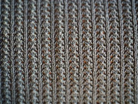 Knitted pattern of gray yarn. Lush machine or hand knitting. Warm wardrobe fo Stock Photos