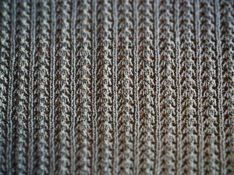Knitted pattern of gray yarn. Lush machine or hand knitting. Warm wardrobe fo Stock Photos