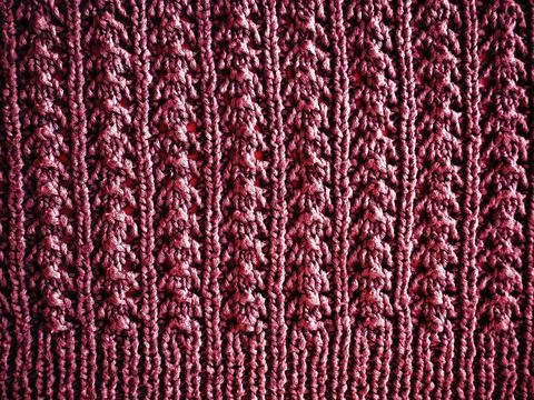 Knitted pattern of pink or red yarn. Lush machine or hand knitting. Warm ward Fotos de archivo