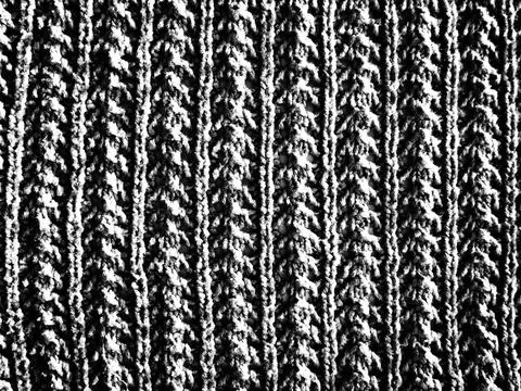 Knitted pattern of wool yarn. Lush machine or hand knitting. Warm wardrobe fo Stock Photos
