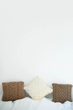 Knitted pillows on the bed Stock Photos