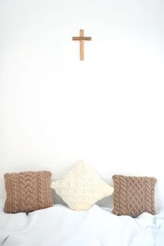 Knitted pillows at the head of the bed Stock Photos