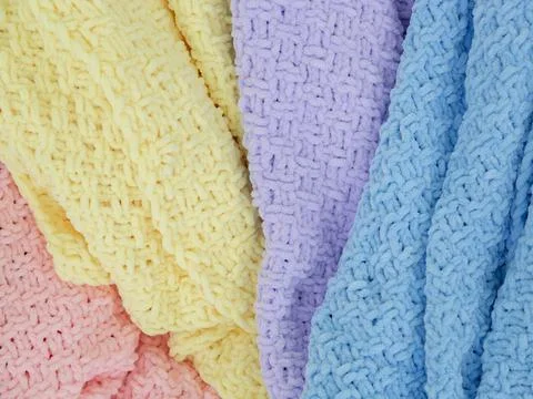 Knitted plaids of different colors. Background. Creases on soft surfaces. Stock Photos