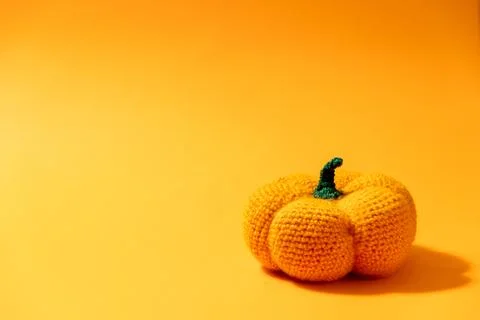 Knitted pumpkin on an orange background with copy space for text Stock Photos