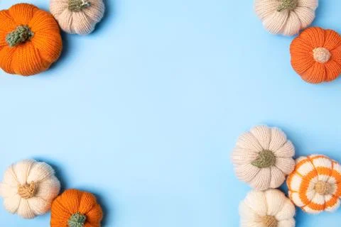 Knitted pumpkins on blue background Stock Photos