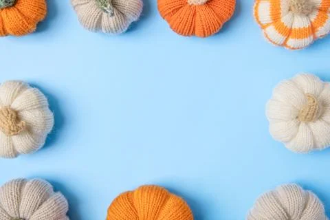 Knitted pumpkins on blue background Stock Photos