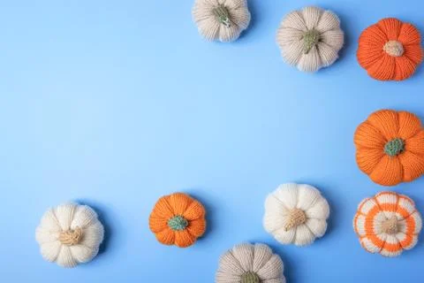 Knitted pumpkins on blue background Stock Photos