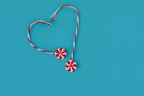Knitted red white round candy caramel two pieces laid out in shape of heart.. Stock Photos