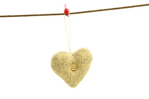 Knitted soft heart with a button hanging on a rope Stock Photos
