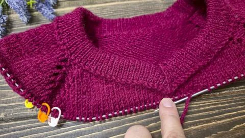 Knitted sweater collar in progress, using knitting needles and stitch markers Stock Photos