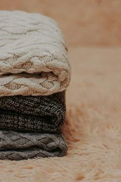 Knitted sweaters on a soft peach carpet close-up Foto stock