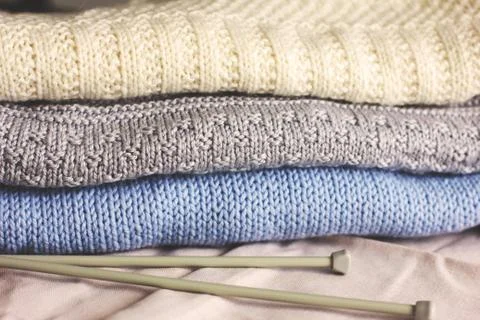 Knitted wool clothes with needles. Warm autumn winter sweaters Stock Photos