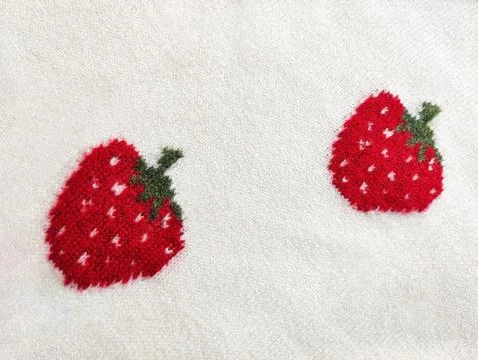 Knitted wool fabric with strawberry pattern. Soft textile material 写真素材