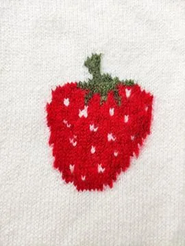Knitted wool fabric with strawberry pattern. Soft textile material Stock Photos