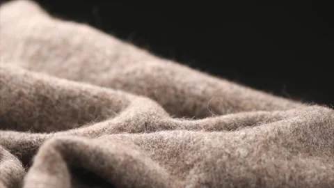 Knitted Wool over black background. Real Natural beige color craft wool mohair  Stock Footage 329801477