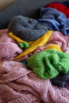 Knitted wool sweaters pile, soft fuzzy textures. Stock Photos