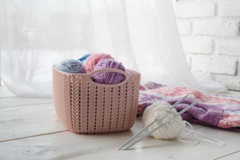 Knitten things and needlework accessories in home organizers colored baskets Stock Photos