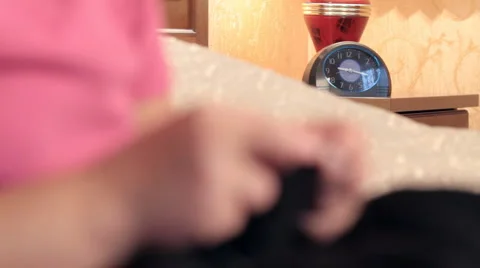 Knitting against lamp with hours. Video stock 949360