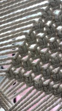 Knitting with beige thread made of wool. Photo in macro mode on the background Stock Photos
