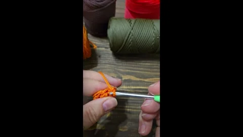 Knitting a cord pattern with a crochet hook. Step-by-step instructions Stock Footage 312055428