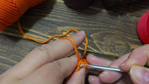 Knitting a cord pattern with a crochet hook. Step-by-step instructions Stock Footage 312055539