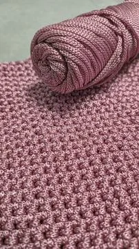 Knitting elements of a pink women's bag, hand knitting with a long handle. Stock Photos