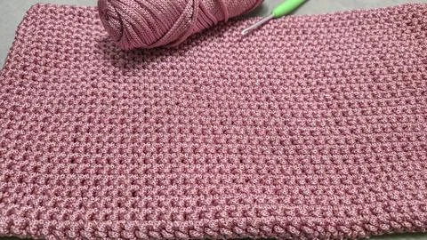Knitting elements of a pink women's bag, hand knitting with a long handle. Stock Photos