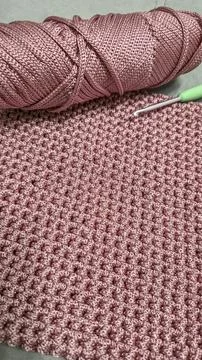 Knitting elements of a pink women's bag, hand knitting with a long handle. Stock Photos