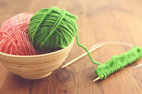 Knitting with green wool on wooden table Stock Photos