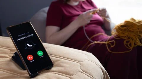 Knitting instead of scrolling while a phone call goes unanswered Stock Photos