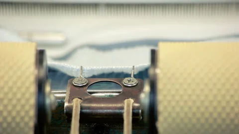 Knitting machine macro. Textile factory equipment feeding white knitted fabric. Stock Footage 345889043