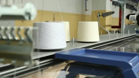 The knitting machine uses threads from bobbins mounted on top. Stock Footage 258662385