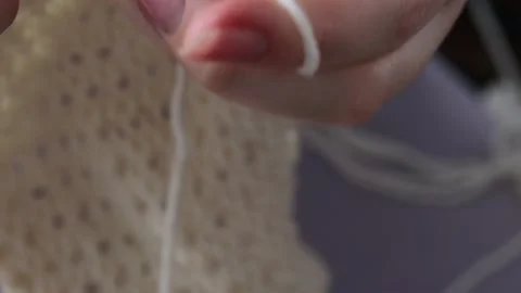 Knitting needle made of light beige threads. the girl knits needle stuff Stock Footage 232608036