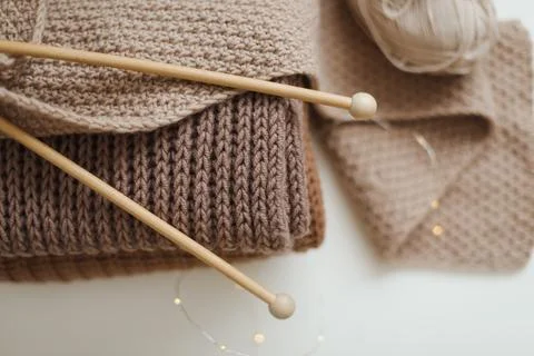 Knitting needles with threads, beige yarn. Hobby for women concept. Knitting Stock Photos