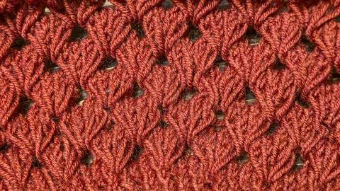 Knitting patterns with a raised pattern made of colored yarn lie on a wooden  库存照片