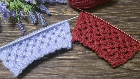 Knitting patterns with a raised pattern made of colored yarn lie on a wooden  Stock Photos