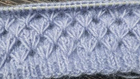 Knitting patterns with a raised pattern made of colored yarn lie on a wooden  Stock Photos