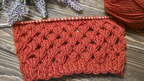 Knitting patterns with a raised pattern made of colored yarn lie on a wooden  Stock Photos