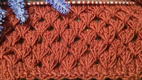 Knitting patterns with a raised pattern made of colored yarn lie on a wooden  Stock Photos