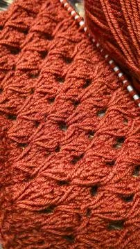 Knitting patterns with a raised pattern made of colored yarn lie on a wooden  Stock Photos