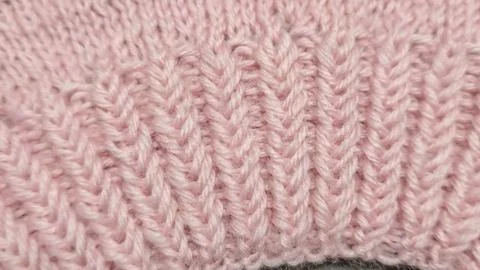 Knitting patterns for sweaters, hats, and other items using light-colored yar Foto stock