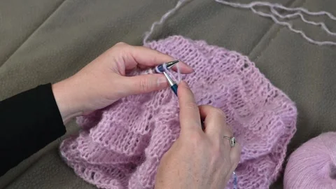 Knitting pink yarn needles, hands working soft wool fabric. Stock Footage 334752192